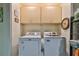 Functional laundry room with a side by side washer and dryer, and plenty of storage cabinets above at 22115 Laver Ln, Land O Lakes, FL 34639