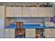 Multi-functional office space with built-in cabinets, drawers, and a blue countertop work area at 22115 Laver Ln, Land O Lakes, FL 34639