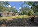 Spacious backyard featuring a private pool, lush greenery, patio area, and mature trees perfect for outdoor living at 2353 Dora Dr, Clearwater, FL 33765