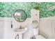 Bathroom with wainscoting, unique wall paper and a round mirror at 2353 Dora Dr, Clearwater, FL 33765