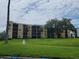 Multi-story condo building with balconies and a well-manicured lawn featuring a fountain at 2424 W Tampa Bay Blvd # M-201, Tampa, FL 33607