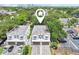 An aerial view of two modern townhomes with a paved driveway and parking, located in a lush, green community near the city at 308 S New Jersey Ave # A, Tampa, FL 33609