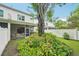 Backyard view featuring lush landscaping, mature trees, and a screened-in lanai at 308 S New Jersey Ave # A, Tampa, FL 33609