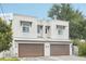 Modern townhome showcasing its two-car garage and white exterior with decorative window accents at 308 S New Jersey Ave # A, Tampa, FL 33609