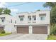 A modern townhome featuring a two-car garage and white exterior with decorative window elements at 308 S New Jersey Ave # A, Tampa, FL 33609