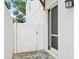 A white fence and entry door with screen leads to the main door, with manicured yard and exterior lighting at 308 S New Jersey Ave # A, Tampa, FL 33609