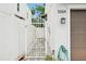 A white metal gate leads to a paved pathway alongside the property with a hose and outdoor lighting visible at 308 S New Jersey Ave # A, Tampa, FL 33609