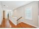 Upstairs hallway with hardwood floors, white trim, and natural light through window at 308 S New Jersey Ave # A, Tampa, FL 33609
