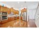 Gourmet kitchen featuring wood cabinets, stainless steel appliances, and mosaic tile backsplash at 308 S New Jersey Ave # A, Tampa, FL 33609