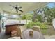 Covered and screened patio with a hot tub, seating, fan and view of lush backyard at 308 S New Jersey Ave # A, Tampa, FL 33609