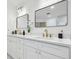 Bright bathroom featuring a dual sink vanity with stone countertops, gold hardware, and decorative details at 3205 Pleasant Lake Dr, Tampa, FL 33618