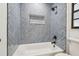 Stylish bathroom featuring a tub with blue herringbone tile surround and matte black fixtures at 3205 Pleasant Lake Dr, Tampa, FL 33618