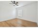 Bright, empty bedroom with light wood floors, ceiling fan, and a large window at 3205 Pleasant Lake Dr, Tampa, FL 33618