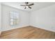 Bright, empty bedroom with light wood floors, ceiling fan, and a large window at 3205 Pleasant Lake Dr, Tampa, FL 33618
