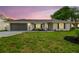 Charming single-story home at dusk with painted brick and attached two-car garage at 3205 Pleasant Lake Dr, Tampa, FL 33618