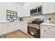 Well-lit kitchen with white cabinets, stainless steel appliances, and quartz countertops at 3205 Pleasant Lake Dr, Tampa, FL 33618