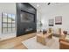 Modern living room featuring an electric fireplace with a stunning accent wall and wood flooring at 3205 Pleasant Lake Dr, Tampa, FL 33618