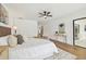 Primary bedroom features a king bed, wood floors, ceiling fan, side tables and a gray accent bench at 3205 Pleasant Lake Dr, Tampa, FL 33618