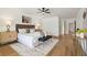 Primary bedroom featuring a king bed, wood floors, ceiling fan, side tables and a gray accent bench at 3205 Pleasant Lake Dr, Tampa, FL 33618