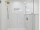 Modern shower with white tiled walls, niche, frameless glass, and rainfall shower head, offering a spa-like experience at 3205 Pleasant Lake Dr, Tampa, FL 33618