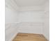 A clean walk-in closet with white walls, wood floors, and wire shelving providing ample space for organization at 3205 Pleasant Lake Dr, Tampa, FL 33618