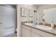 Well-lit bathroom features a double vanity with granite countertops and a shower-tub combination at 32442 Osprey Peak Way, San Antonio, FL 33576