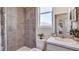 This bathroom features neutral tile and decor, a shower and an adjacent view into the kitchen at 32442 Osprey Peak Way, San Antonio, FL 33576