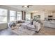 Bright living room with large windows, a comfortable sofa, and an open view to the kitchen and dining area at 32442 Osprey Peak Way, San Antonio, FL 33576
