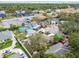 A residential community featuring diverse architectural styles, mature trees, and a mix of residential and commercial properties at 361 Colonial Ct, Dunedin, FL 34698