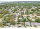 This aerial shot focuses on a residential area featuring tree-lined streets, well-maintained homes and mature landscaping at 361 Colonial Ct, Dunedin, FL 34698