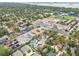 This aerial view features a neighborhood close to commercial spaces and a large baseball stadium near the coast at 361 Colonial Ct, Dunedin, FL 34698