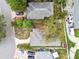 This close aerial shot shows residences with varying roof types, surrounded by trees and well-kept properties at 361 Colonial Ct, Dunedin, FL 34698