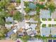 This overhead view highlights homes in a well-maintained neighborhood, featuring mature trees and private driveways at 361 Colonial Ct, Dunedin, FL 34698