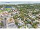 A wide aerial shot displays a neighborhood with tree-lined streets near a baseball stadium and commercial buildings at 361 Colonial Ct, Dunedin, FL 34698