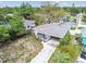 Aerial view of a cozy home with a convenient carport, enclosed porch, and a low-maintenance yard in a quiet neighborhood at 361 Colonial Ct, Dunedin, FL 34698