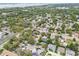 This aerial view captures a neighborhood with lush trees, showcasing its proximity to nearby roads and community spaces at 361 Colonial Ct, Dunedin, FL 34698