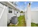 An air conditioning unit is located at the side of the house next to the backyard at 361 Colonial Ct, Dunedin, FL 34698
