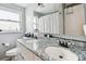Bathroom featuring double sinks, granite countertops and a well-lit vanity area at 361 Colonial Ct, Dunedin, FL 34698