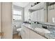 Bathroom featuring double sinks, granite countertops and a well-lit vanity area at 361 Colonial Ct, Dunedin, FL 34698