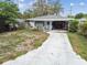 Cozy one-story home featuring covered parking and a screened-in porch, perfect for enjoying the outdoors at 361 Colonial Ct, Dunedin, FL 34698