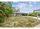 Single-story home with a carport and small front lawn, surrounded by trees at 361 Colonial Ct, Dunedin, FL 34698