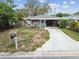 Charming single-story home with a mailbox, driveway, and a simple lawn, ready for a personal touch at 361 Colonial Ct, Dunedin, FL 34698