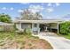 Charming home with a covered carport, front porch, and light blue door at 361 Colonial Ct, Dunedin, FL 34698