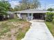 Charming single-story home features a covered parking area and a cozy screened-in porch for relaxing outdoors at 361 Colonial Ct, Dunedin, FL 34698