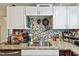 Bright kitchen featuring granite countertops, mosaic tile backsplash and stainless steel appliances at 361 Colonial Ct, Dunedin, FL 34698