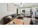 Cozy living room featuring a comfortable leather sectional, tile flooring, and natural light at 361 Colonial Ct, Dunedin, FL 34698