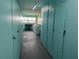 Hallway with laundry room in the background and storage lockers on the sides at 3850 13Th N Ave # 311, St Petersburg, FL 33713
