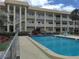 Exterior shot of condo building with a fenced in pool and outdoor seating at 3850 13Th N Ave # 311, St Petersburg, FL 33713