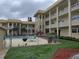 Exterior shot of condo building with a fenced pool, seating, and landscaping at 3850 13Th N Ave # 311, St Petersburg, FL 33713