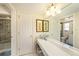 Well-appointed bathroom showing vanity, mirror and tiled walk-in shower in neutral tones at 4326 Great Lakes N Dr, Clearwater, FL 33762
